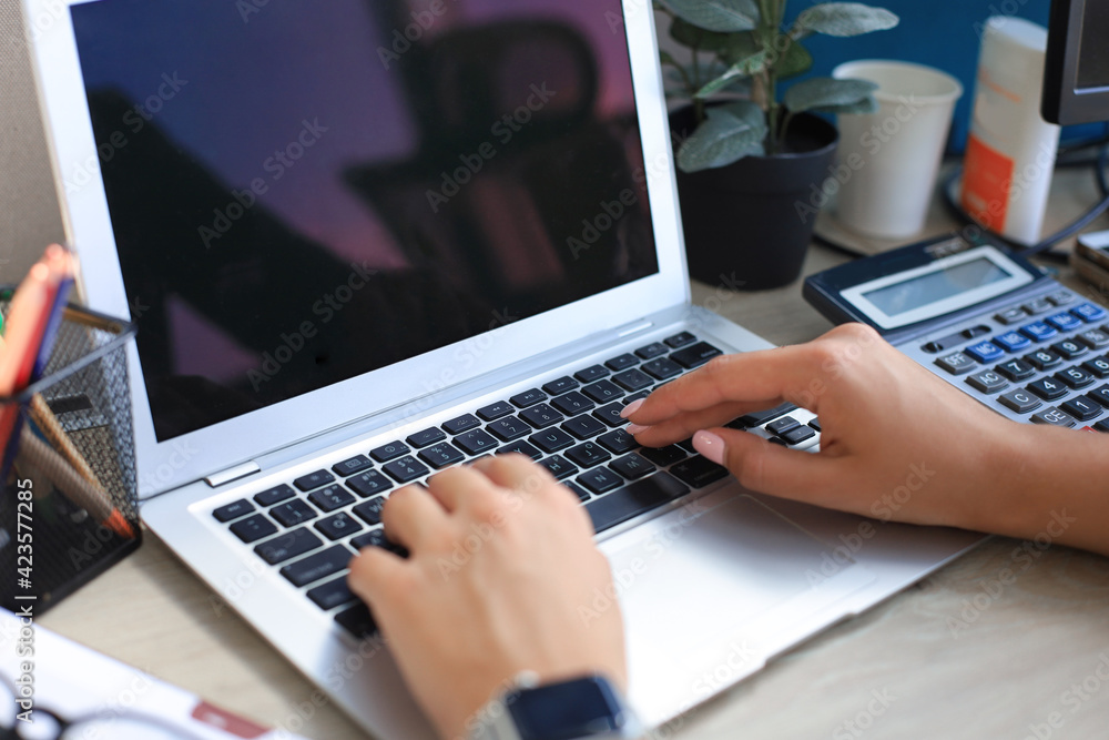 Woman hands pressing keys on a laptop keyboard in office. Woman hands pressing keys on a laptop keyboard in office.