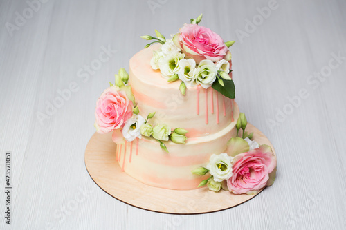 Tiered cake with fresh flowers and macaroons