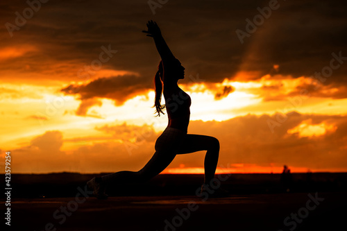 Sunset yoga. Beautiful yoga girl silhouette at the sunset.