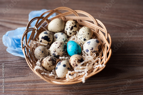 easter eggs in a wicker basket on a wooden background