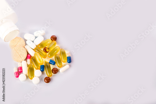 pills of different shapes and colors on a white background