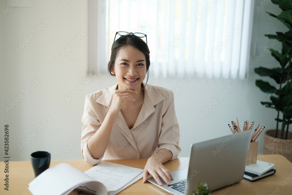 Portrait of happy woman sitting at her office. Attractive young confident business woman or accountant smiling and have idea for her big project. Portrait of happy woman sitting at her office. Attractive young confident business woman or accountant smiling and have idea for her big project.