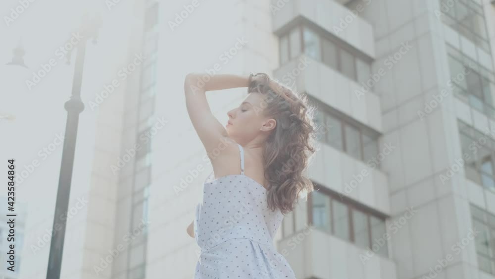 Beautiful posing near an iron fence against the background of a modern building Beautiful posing near an iron fence against the background of a modern building
