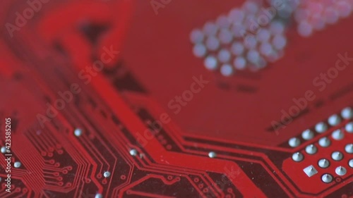 Red board with chips and microcircuits in slow motion