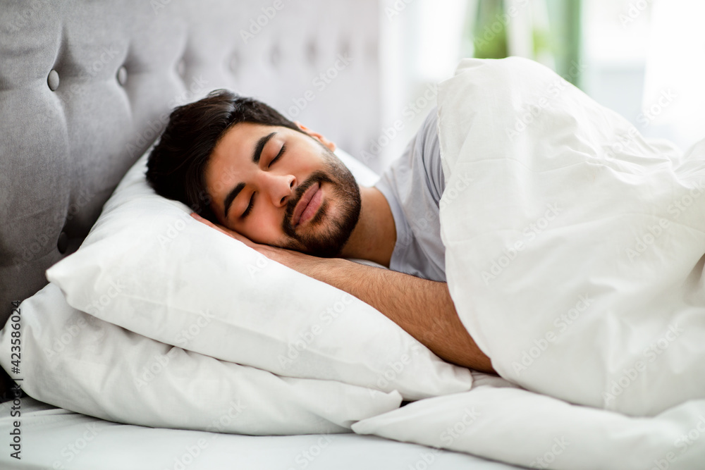 Just resting. Asleep arab man resting peacefully in his comfortable bed at home, having good dreams Just resting. Asleep arab man resting peacefully in his comfortable bed at home, having good dreams
