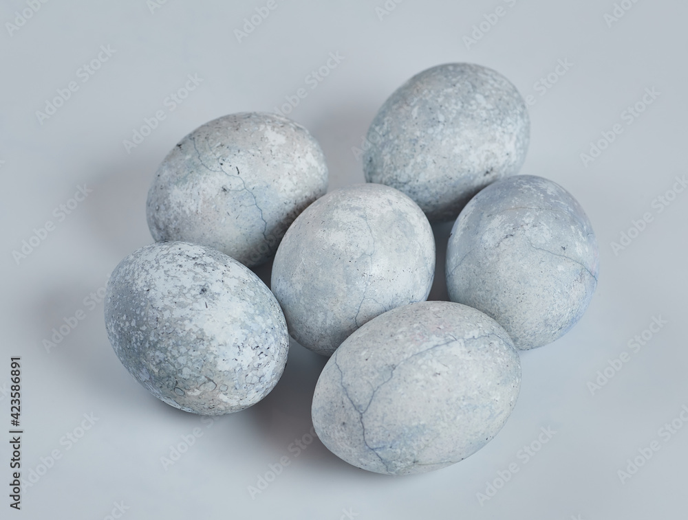 Painted eggs in blue and white lie on a white background. Painted eggs in blue and white lie on a white background.