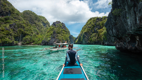 El Nido, Palawan Island, Philippines, traveler sitting on boat deck exploring the natural sights around El Nido on a sunny day. photo