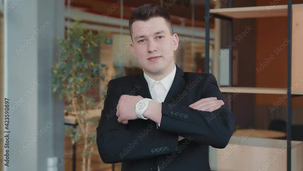 Portrait of a young student and maybutny business man in the room. The young man of the Caucasian nationality sings his hand on hand and marvels at the camera. Portrait of a young student and maybutny business man in the room. The young man of the Caucasian nationality sings his hand on hand and marvels at the camera.
