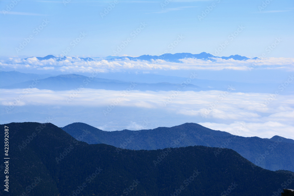 夏空、標高日本第3位の名峰、奥穂高岳山頂から、雲海に浮かぶ八ヶ岳の山容。全容。全貌。