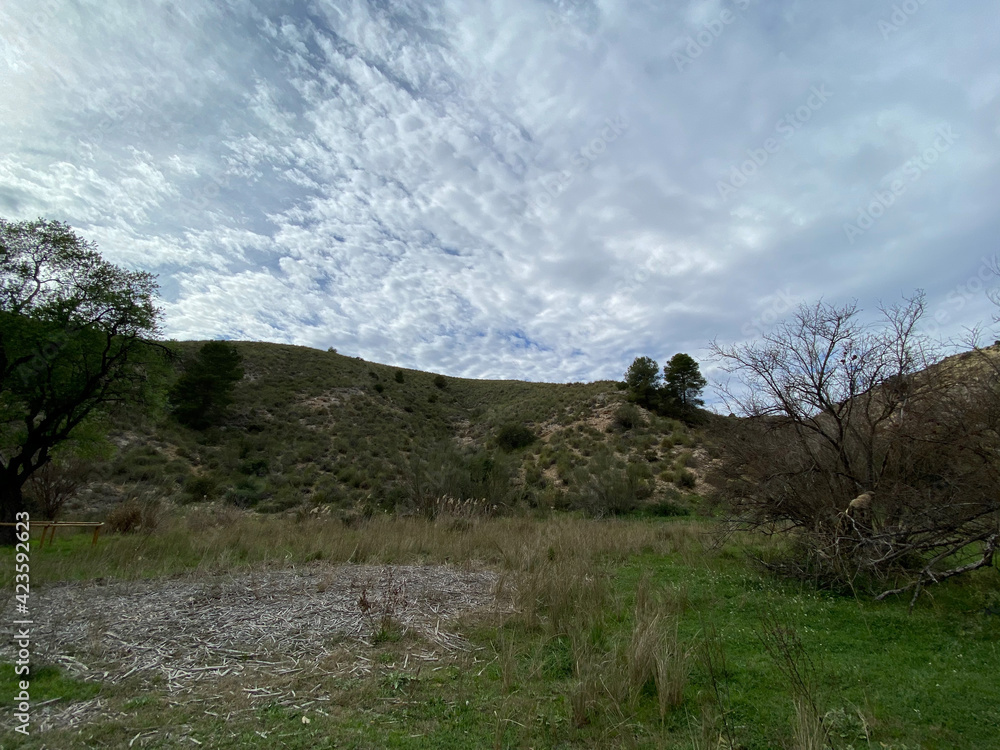 view of a hiking trail along the river with rocks, mountains and lots of vegetation in Spain.