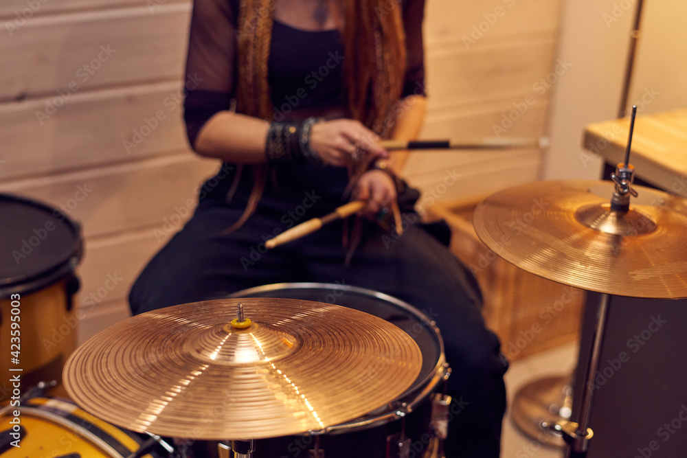 Obraz premium Close-up of woman holding sticks and playing drums during performing