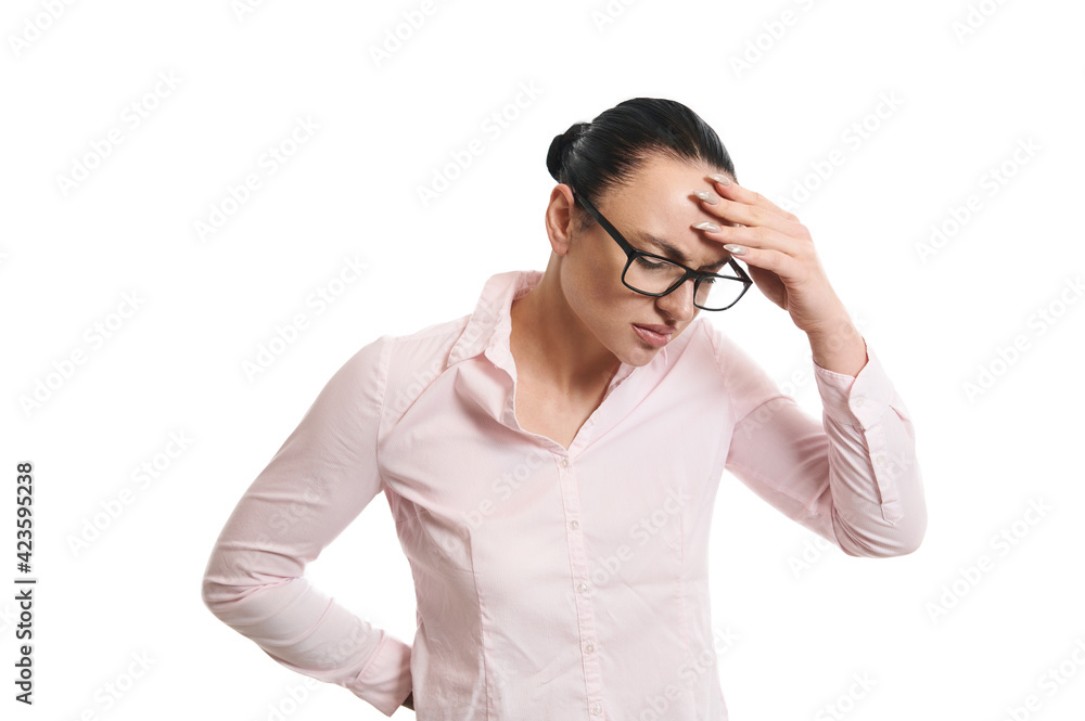 Young woman looking down and placing her hand on her forehead, expressing confusion. Isolated. White background. Copy space. Young woman looking down and placing her hand on her forehead, expressing confusion. Isolated. White background. Copy space.