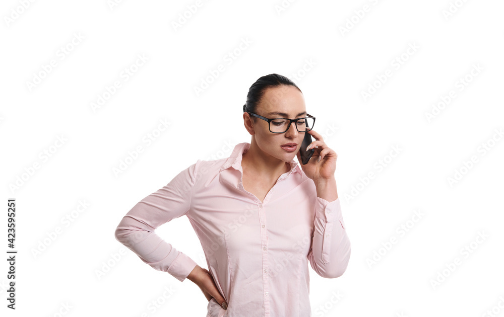 Young brunette woman wearing business casual clothes talking on mobile phone while standing isolated on white background with copy space Young brunette woman wearing business casual clothes talking on mobile phone while standing isolated on white background with copy space
