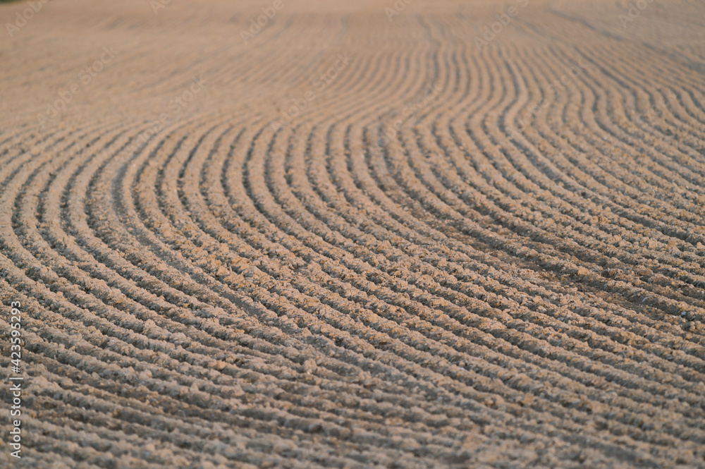 Naklejka premium Furrows row pattern in a plowed field at springtime