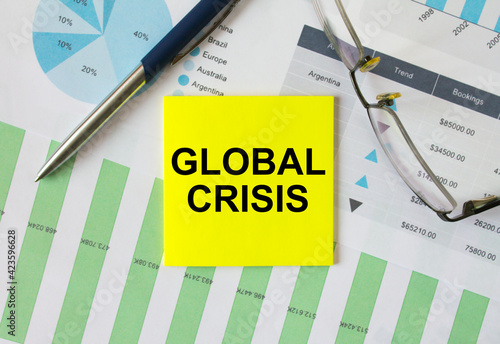 Wallpaper Mural Yellow sticker with text Global Crisis lies on financial charts with pen and eyeglass Torontodigital.ca