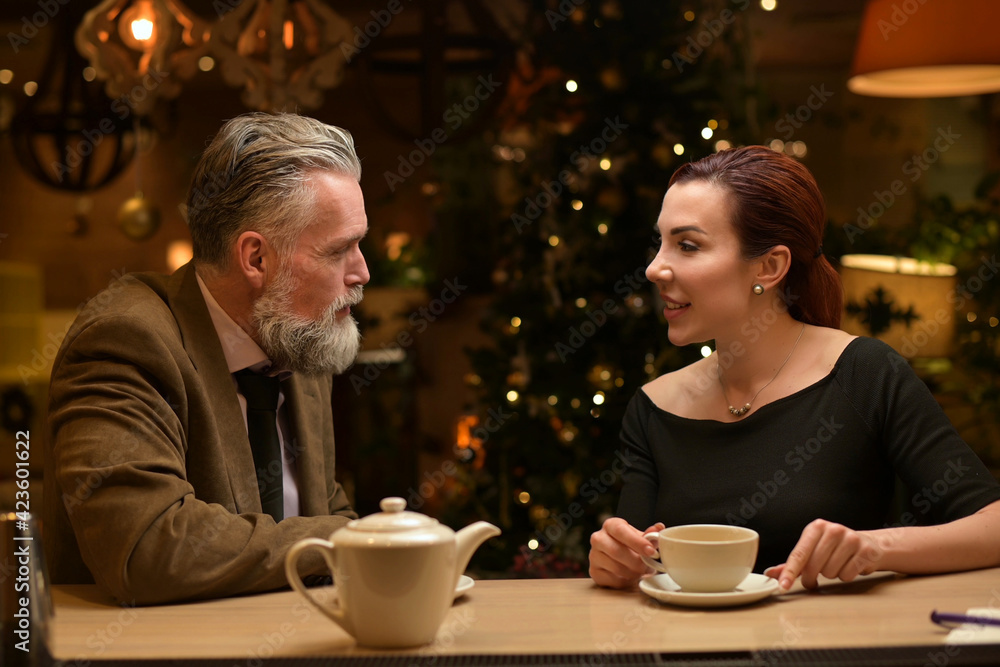 a man and a woman chat and drink tea at the bar in a restaurant a man and a woman chat and drink tea at the bar in a restaurant