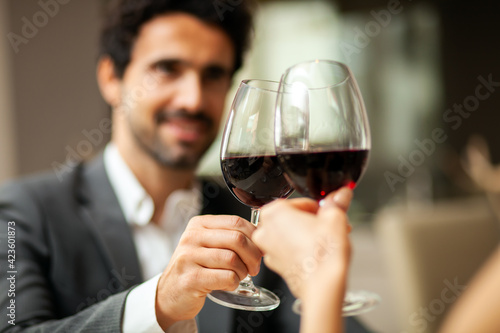 Handsome man tasting a glass of red wine