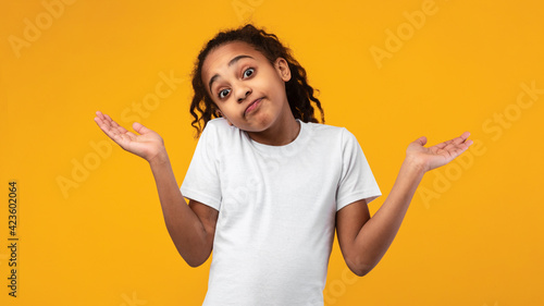 I Don't Know. Confused puzzled black girl shrugging at studio photo