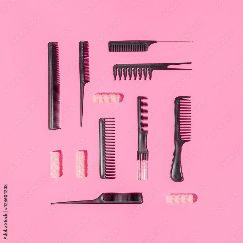 Collection of professional hairdresser combs and curlers arranged on pink background. Minimal flat lay concept. Collection of professional hairdresser combs and curlers arranged on pink background. Minimal flat lay concept.