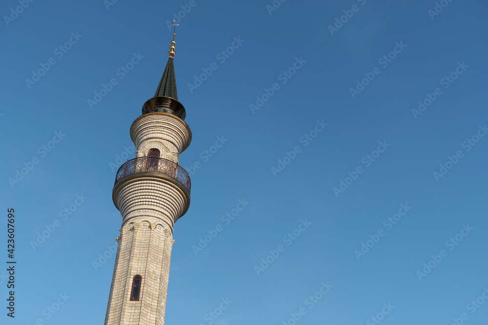 Minaret of the mosque against the blue sky. Islam in Europe