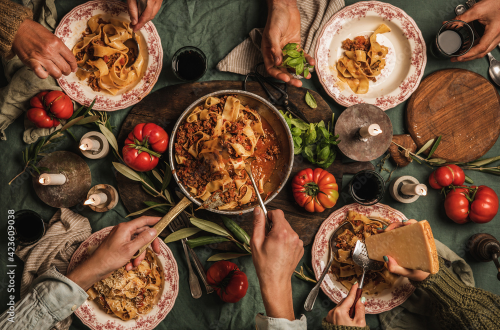 Fototapeta premium Family eating pasta Bolognese at Italian style dinner