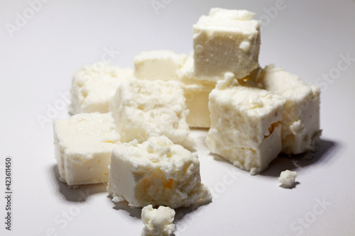 cubes of fresh sheep cheese on a light background