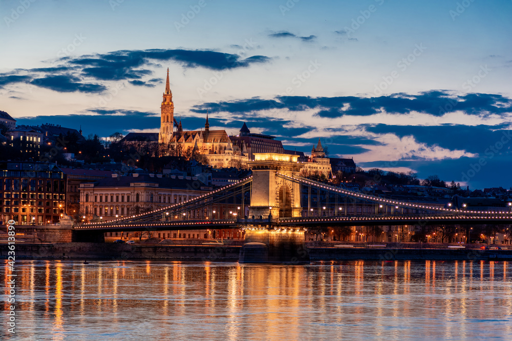 Twilight in Budapest, the Chain Bridge over the Danube, the reflection of night lights on the water - obrazy, fototapety, plakaty 