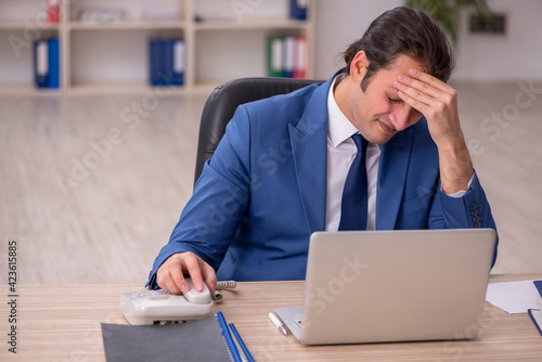 Young male employee sitting in the office