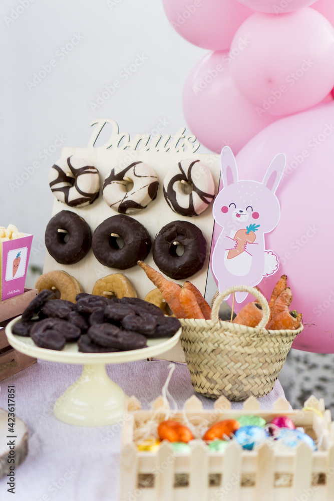 candy table decorated with easter bunny and carrots. close-up candy and wicker basket with carrots candy table decorated with easter bunny and carrots. close-up candy and wicker basket with carrots
