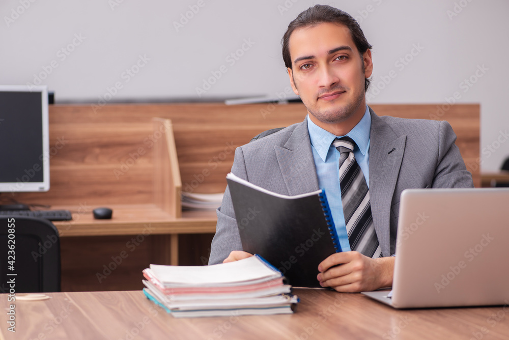Young male employee working in the office Young male employee working in the office