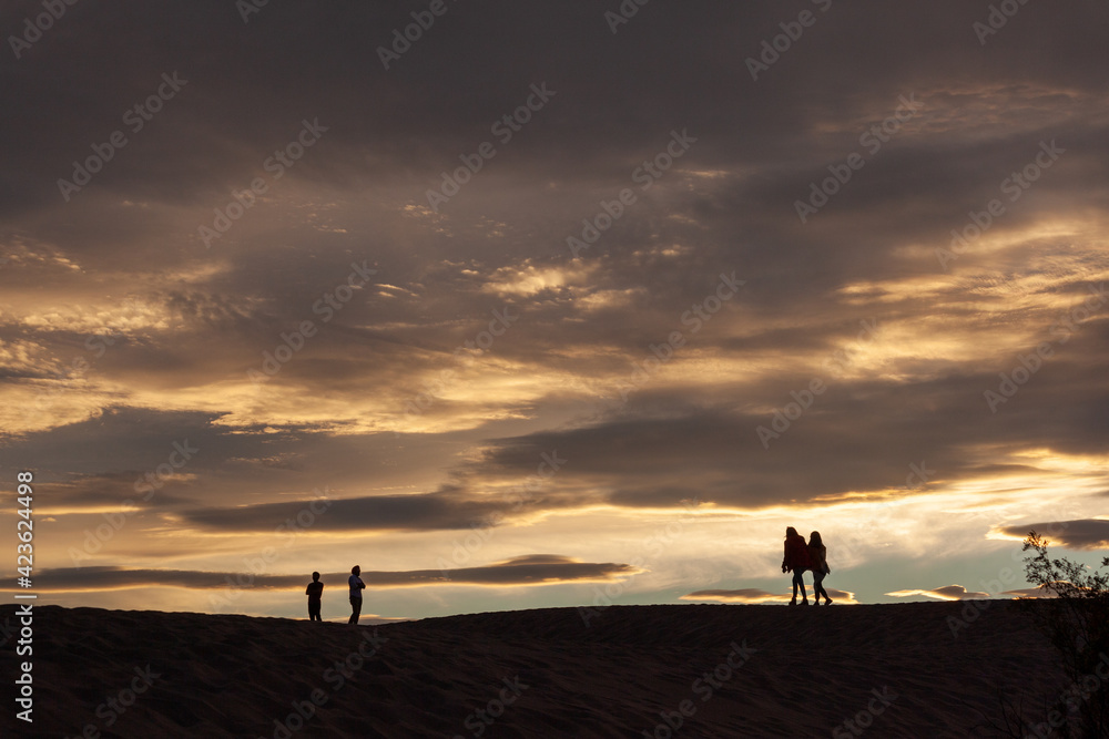 silhouette of people in the desert at sunset