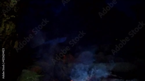 a man sitting alone in front of campfire bonfire at indonesian family fun campin photo