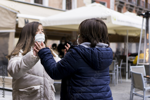 children with face masks playing in the street