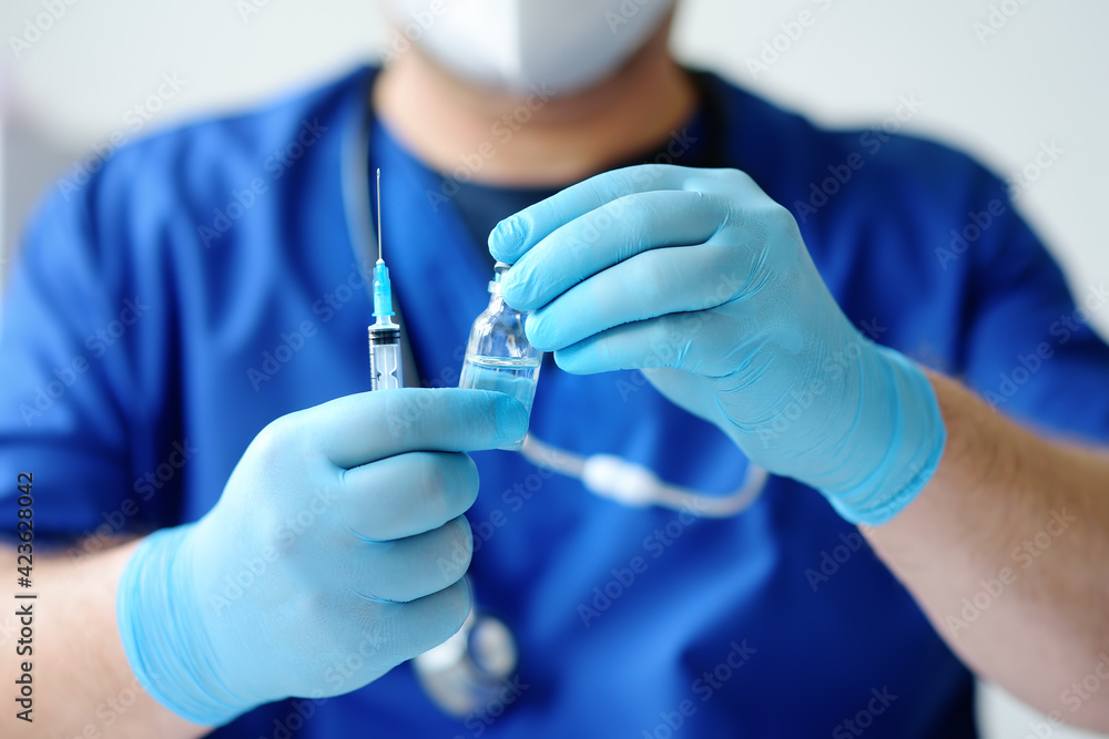 Doctor or nurse is preparing to give injection vaccine against covid-19. Mass vaccination of the population will help stop the spread of coronavirus in the world. Doctor or nurse is preparing to give injection vaccine against covid-19. Mass vaccination of the population will help stop the spread of coronavirus in the world.