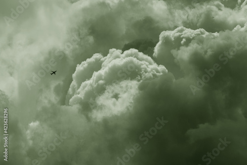 Airplane high in the puffy sky © taffpixture