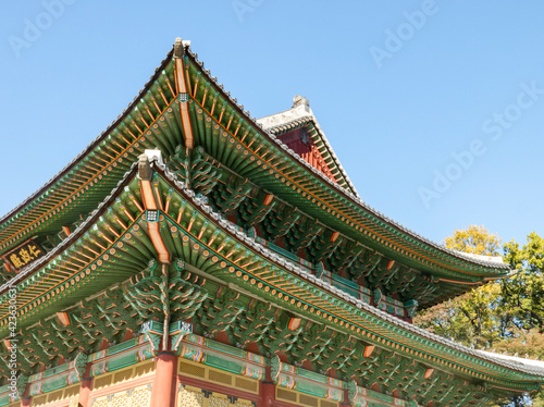 A fragment of the wooden, carved and colorful roof of the Injeongjeon Hall in the Changdeokgung Palace in Seoul, South Korea