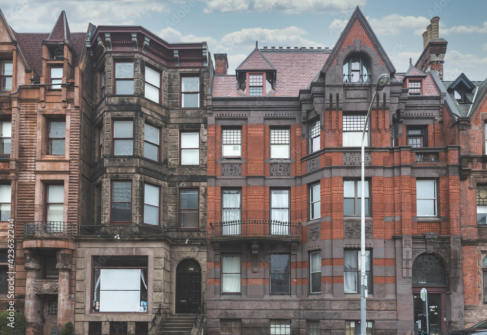 Street view of an old, red brick apartment building in Philadelphia