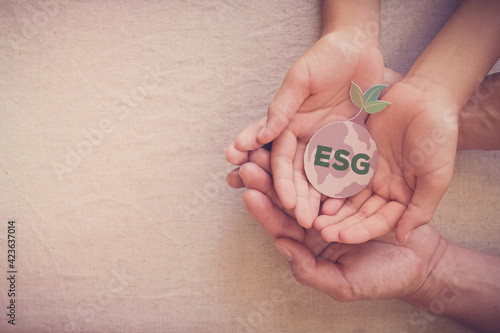 Hands holding growing tree on earth, ESG Environmental, social and corporate governance concept