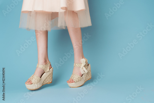 Fototapeta Naklejka Na Ścianę i Meble -  Womens feet shoes blue background fashionable clothes elegant style