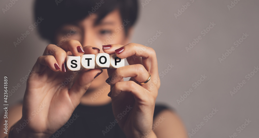 Stop asian hate hashtag, support Asian americans communities, stop hate crimes campaign. A beautiful Asian woman hold letter word "STOP". Hate is a virus, Against racism, Campaign, Anti-AAPI, Concept. - obrazy, fototapety, plakaty 
