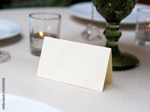Mockup white blank space card, for Name place, Folded, greeting, invitation on wedding table setting background. with clipping path