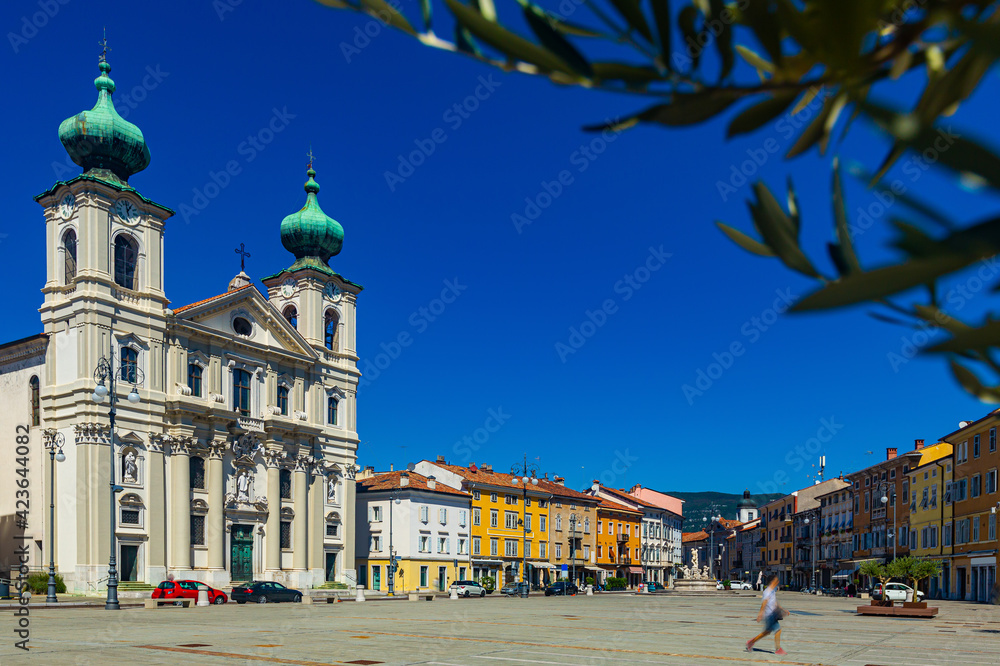 Imposing building of Church of St. Ignatius with two bell towers on Victory Square (Piazza della Vittoria) on sunny autumn day, Gorizia, Italy