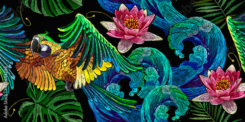 Colorful flying ara parrots, palm leaves, sea waves and pink lotus flowers seamless pattern. Macaws. Fashionable template for design of clothes, textiles. Magic romantic tropical background