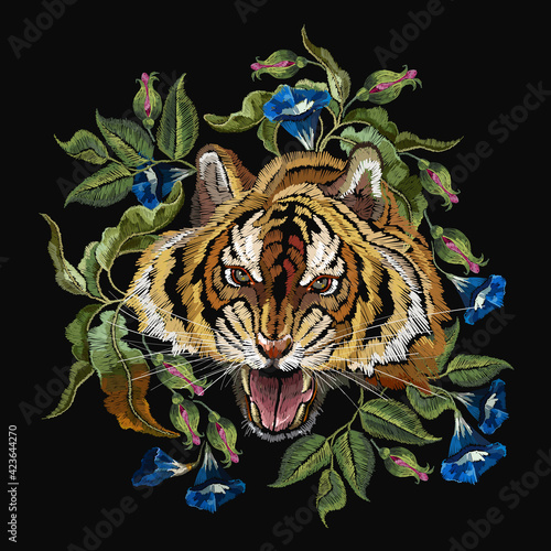 Embroidery tiger head and beautiful blue flowers. Wild animals art. Fashionable template for design of clothes, t-shirt design