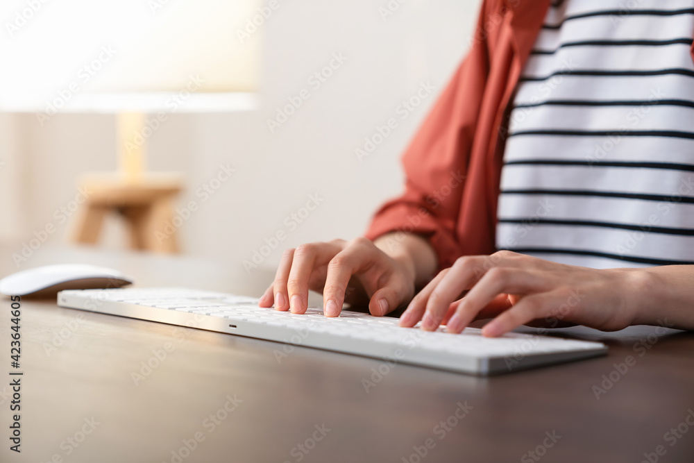 Fototapeta premium Hand holding a computer mouse and keyboard on the office desk.