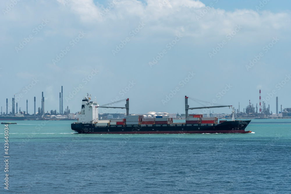 Container ship arriving to the cargo terminal in Singapore. Vessel is loaded with goods stored inside containers. Container ship arriving to the cargo terminal in Singapore. Vessel is loaded with goods stored inside containers.