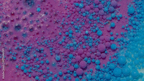Macro structure of multicolored water paint oil bubbles. Purple blue acrylic painting. Fantastic surface with chaotic motion liquid. Top view. Mobile phone screen style, theme wallpaper background