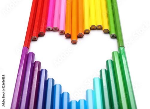 Heart shape made of colorful pencils on white background