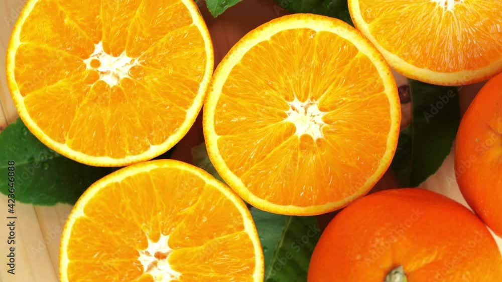 Orange fruit with slices closeup, Top view Rotate fruits, Sweet orange fruit with green leaves in the garden. Orange fruit with slices closeup, Top view Rotate fruits, Sweet orange fruit with green leaves in the garden.