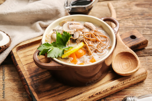 Cooking pot with Thai noodle soup on wooden background